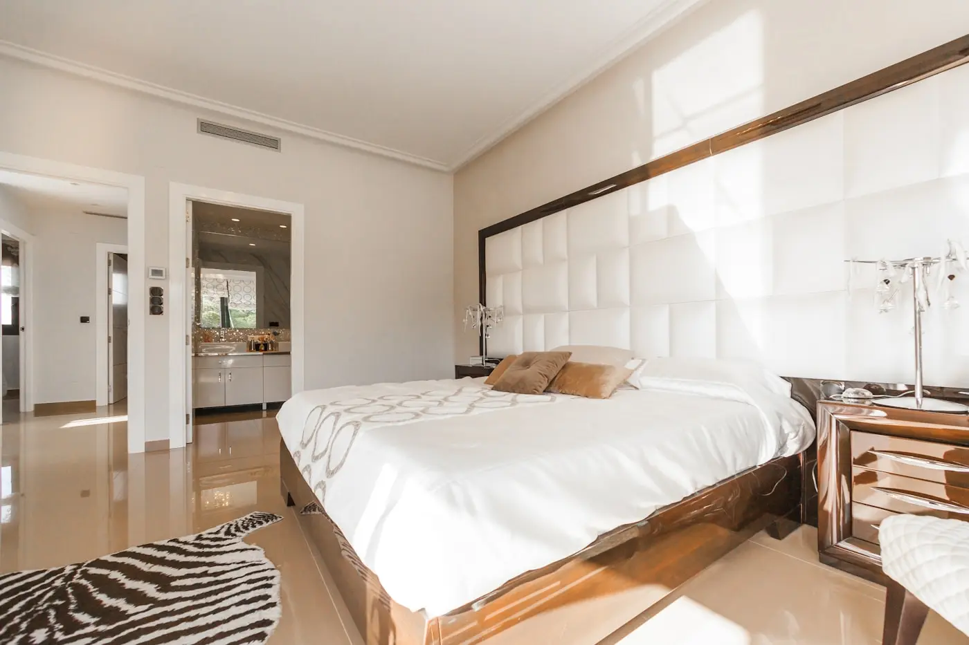Mini suite con cama king y cabecera acolchada en tonos claros